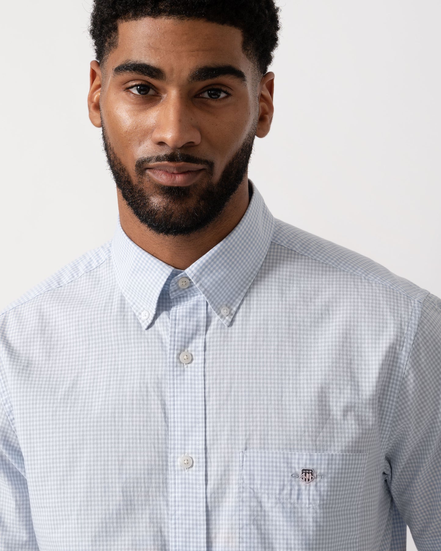 Model wearing a GANT Mens Regular Fit Classic Poplin Gingham Short Sleeve Shirt in 455 Light Blue - detail