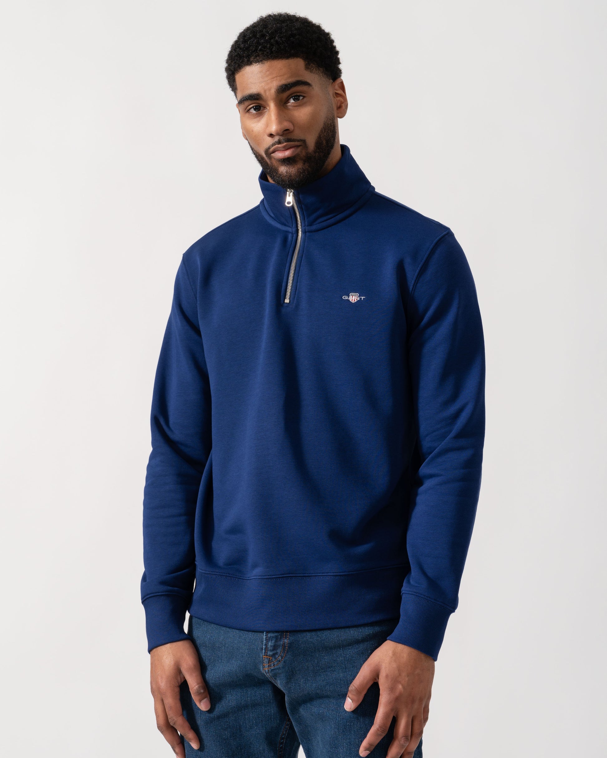 Model wearing GANT Mens Regular Fit Shield Logo Half Zip Sweatshirt in 432 Rich Navy - Main