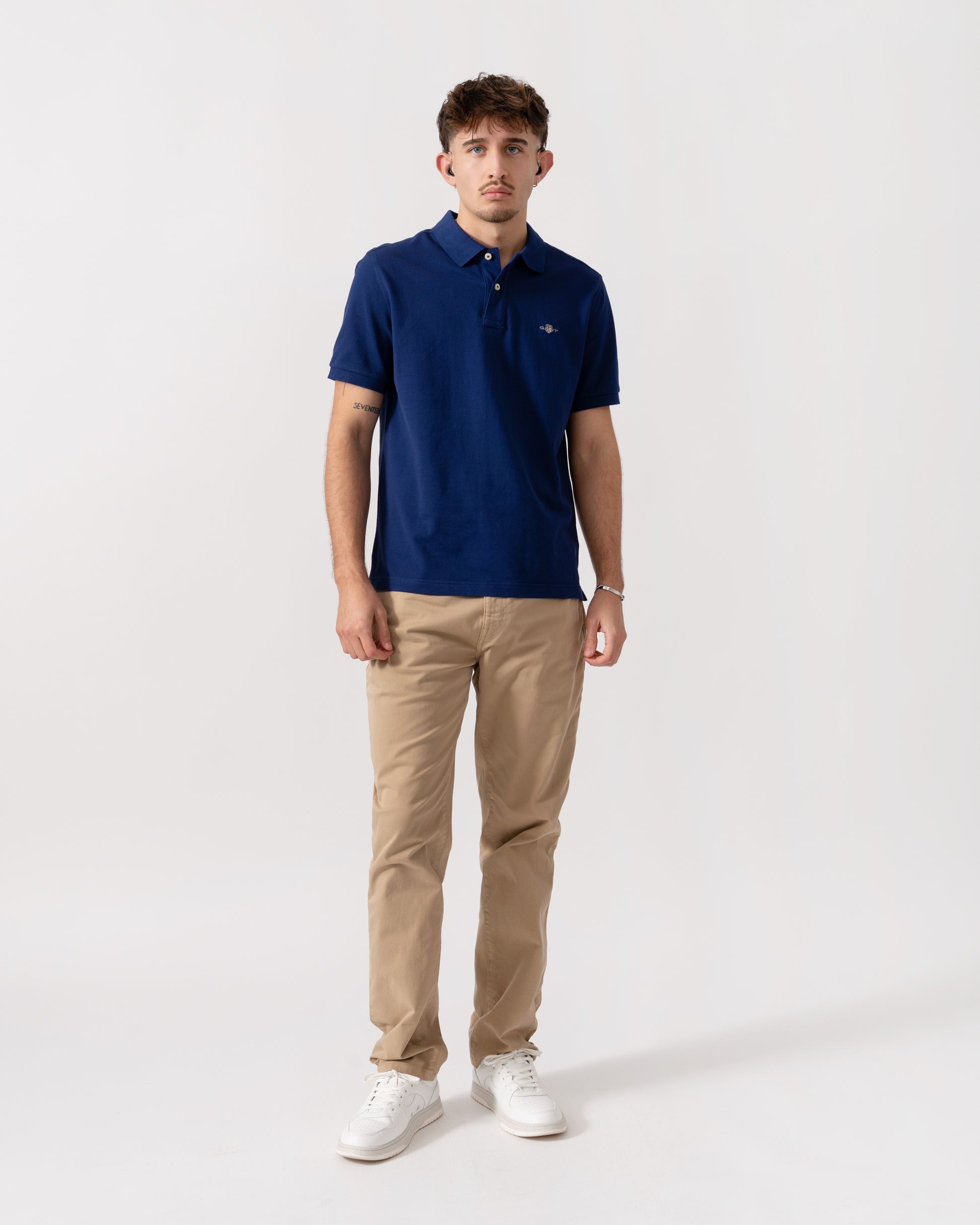 Model wearing GANT Mens Regular Fit Short Sleeve Shield Logo Pique Polo in 432 Rich Navy - Full length