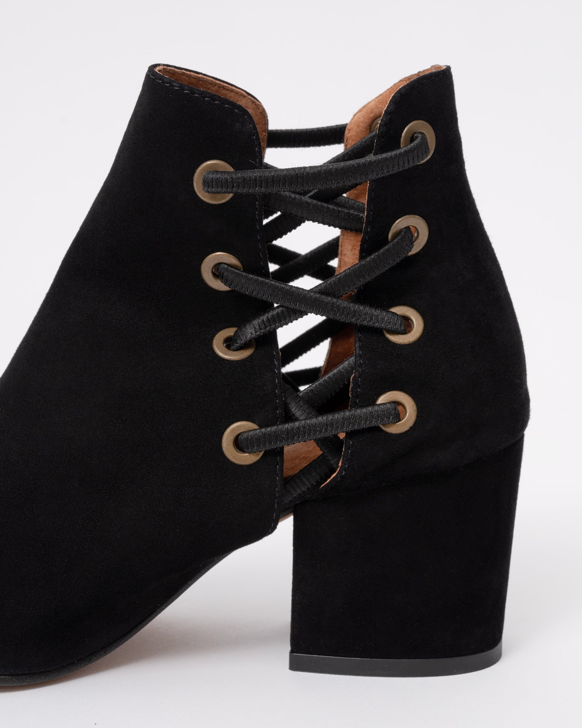 Black suede lace-up boots with a block heel on a white background