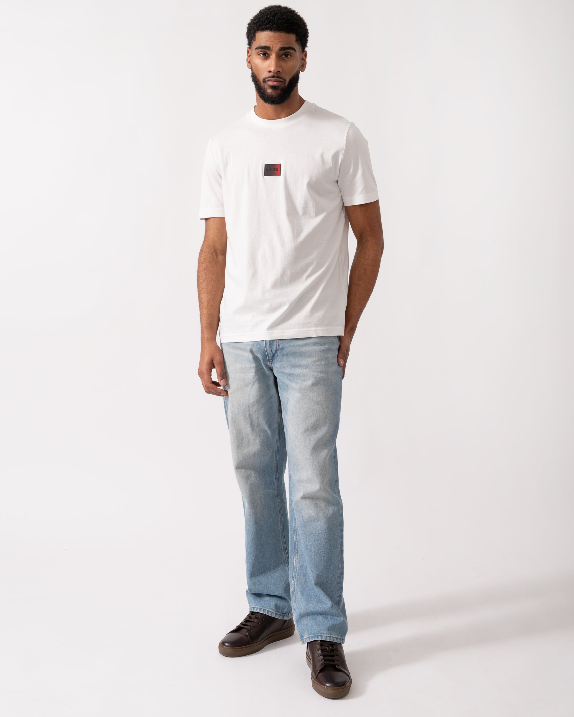full length of a model wearing a HUGO Danotie Mens Red Label Logo T-Shirt in natural white