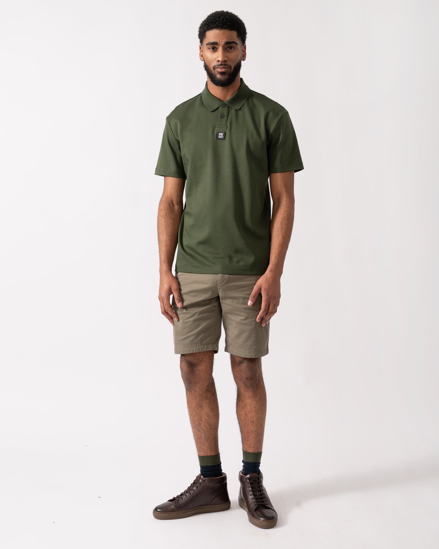 full length of a model wearing a HUGO Deabono Mens Interlock Cotton Polo Shirt with Stacked Logo in Dark Green