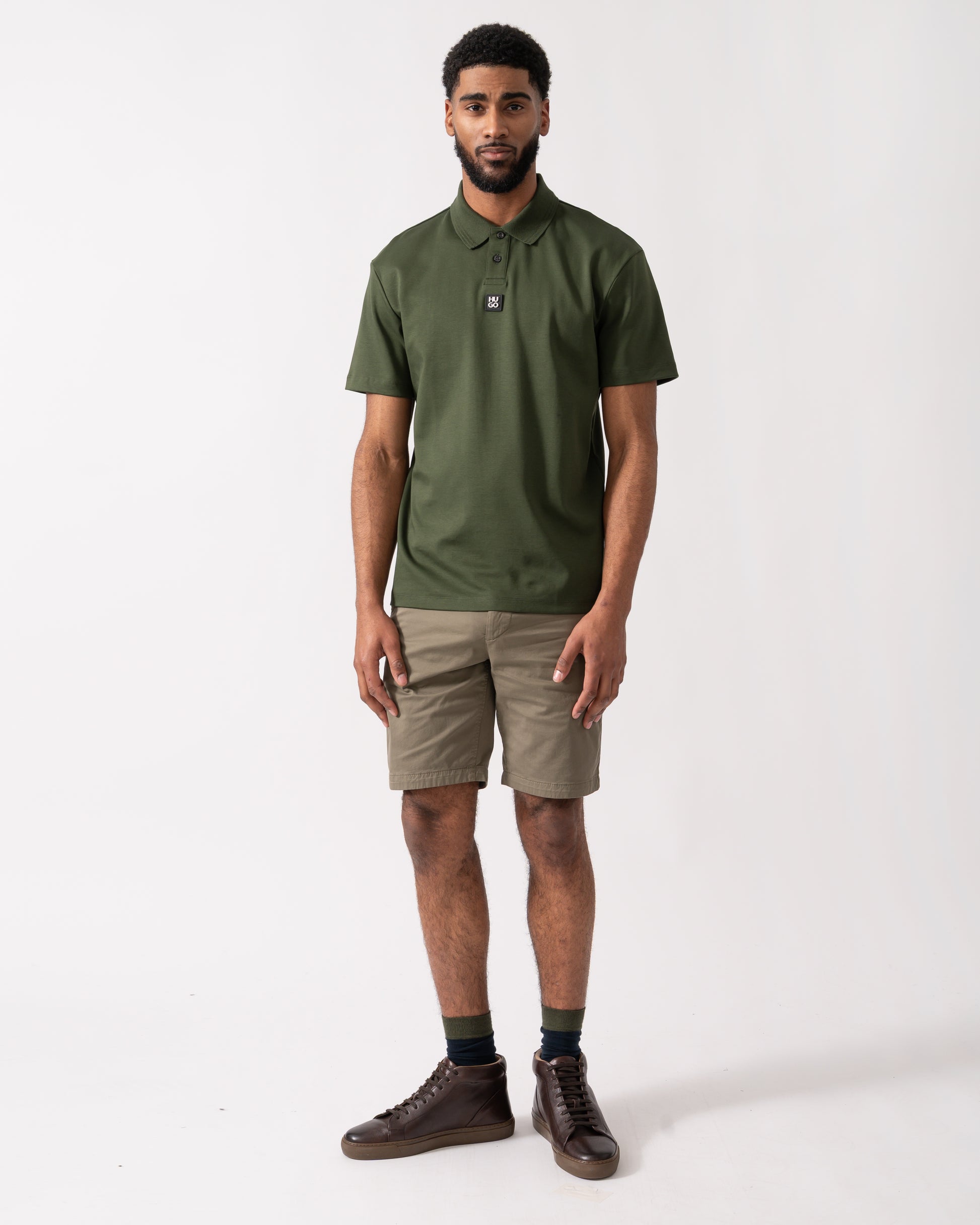 full length of a model wearing a HUGO Deabono Mens Interlock Cotton Polo Shirt with Stacked Logo in Dark Green