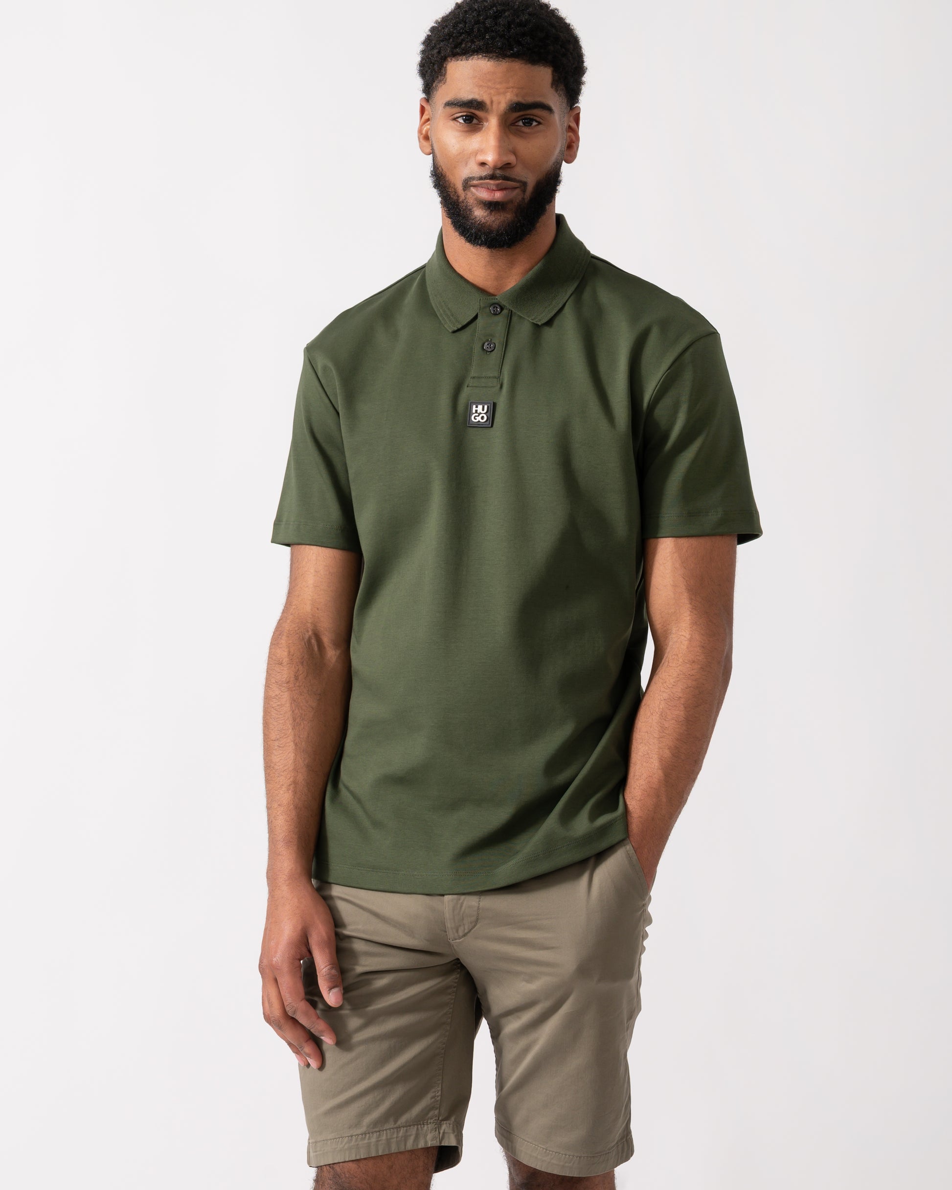 model wearing a HUGO Deabono Mens Interlock Cotton Polo Shirt with Stacked Logo in Dark Green
