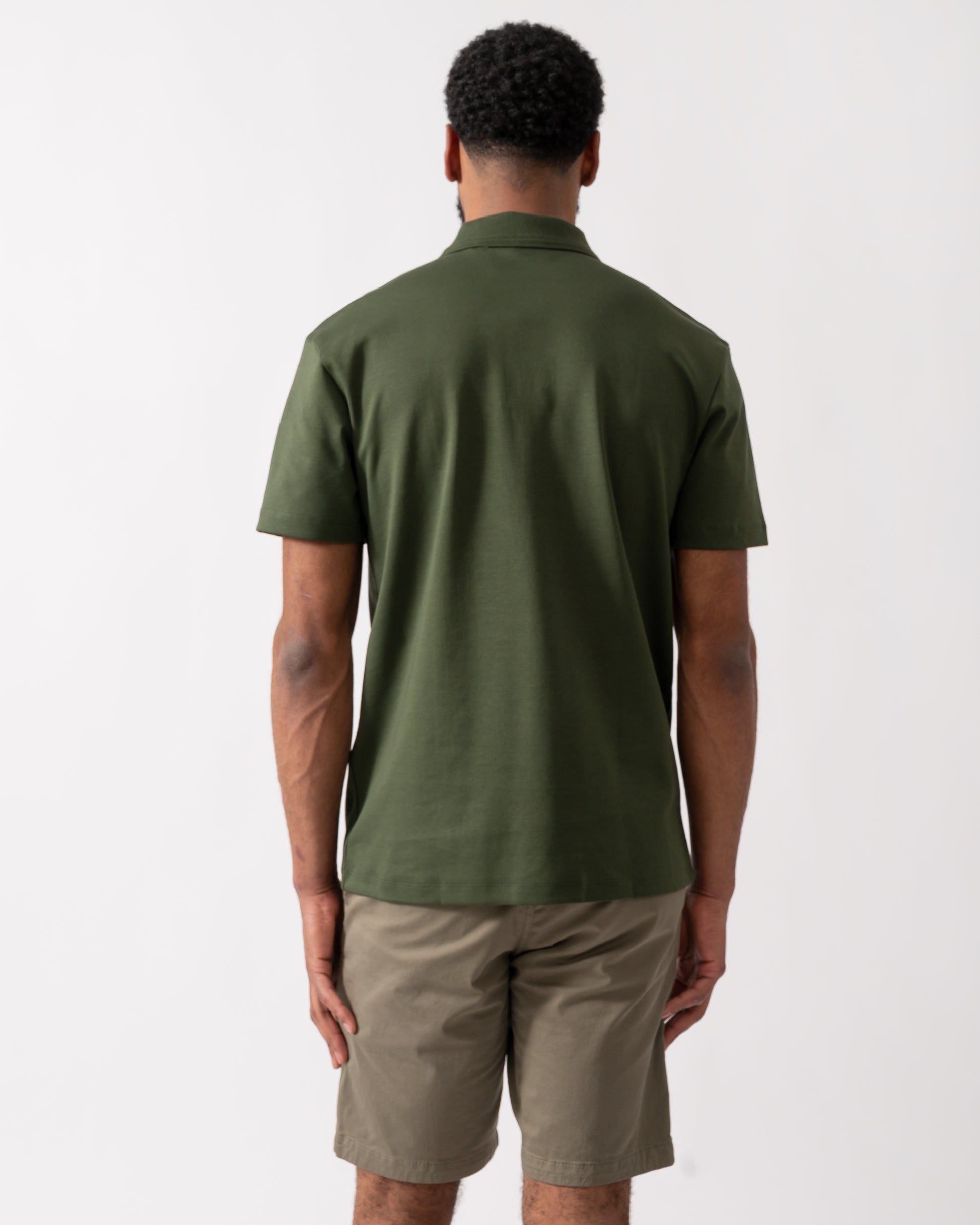 back of a model wearing a HUGO Deabono Mens Interlock Cotton Polo Shirt with Stacked Logo in Dark Green