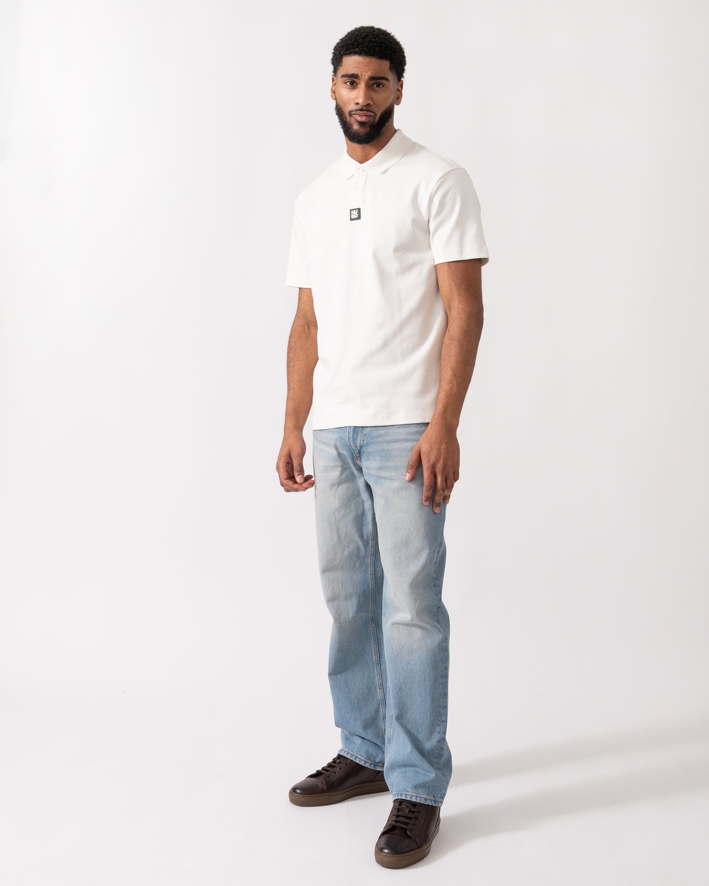 full length of a model wearing a HUGO Deabono Mens Interlock Cotton Polo Shirt with Stacked Logo in Natural white