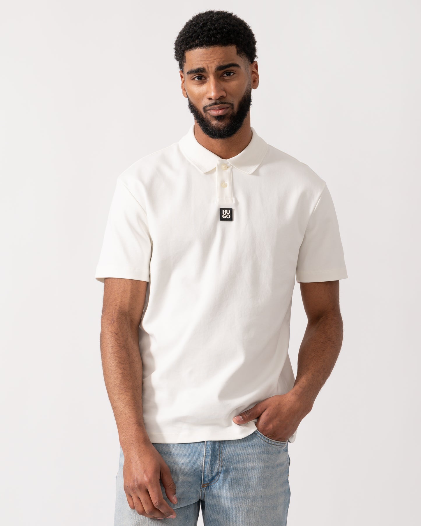 model wearing a HUGO Deabono Mens Interlock Cotton Polo Shirt with Stacked Logo in Natural white