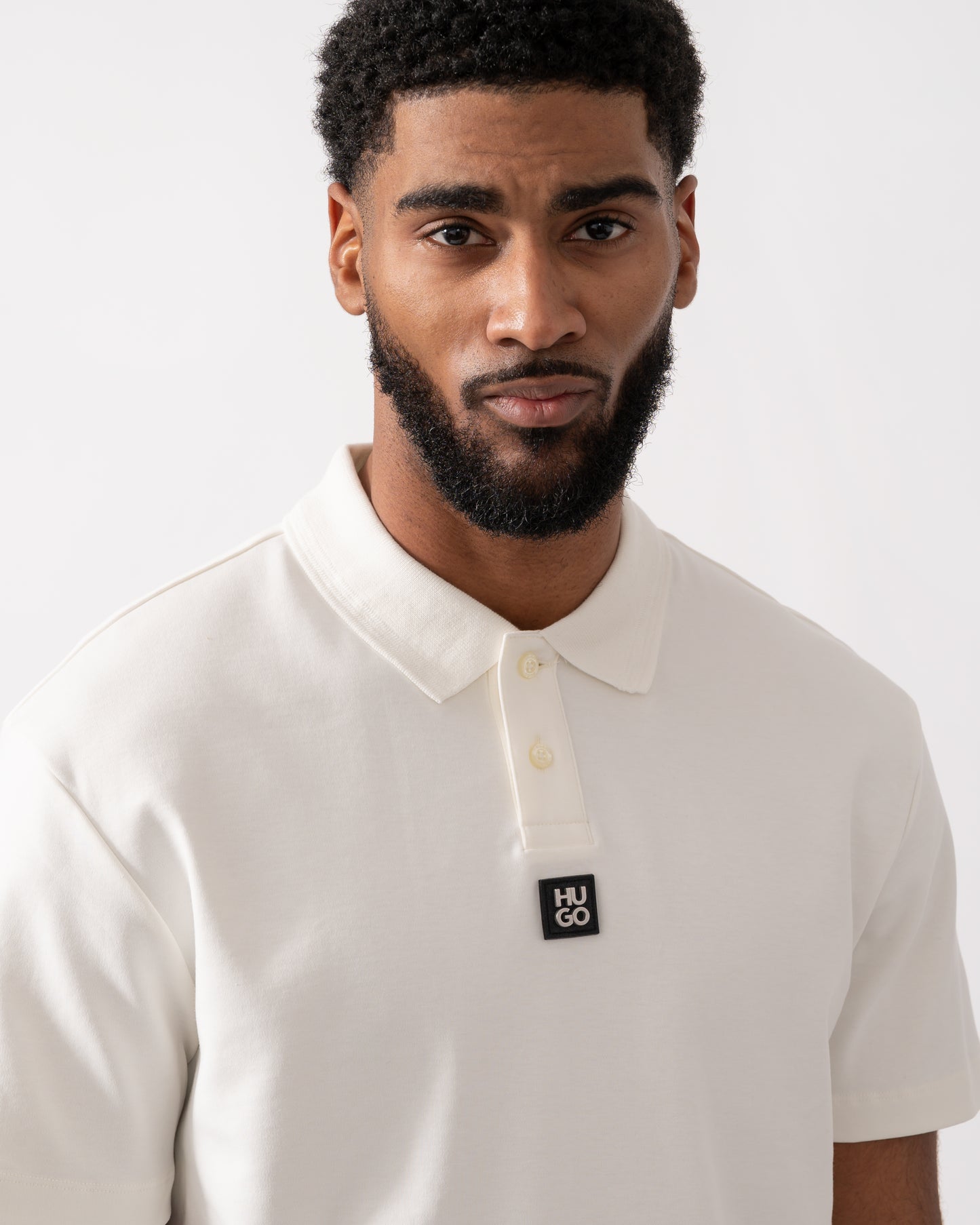 close up of a model wearing a HUGO Deabono Mens Interlock Cotton Polo Shirt with Stacked Logo in Natural white