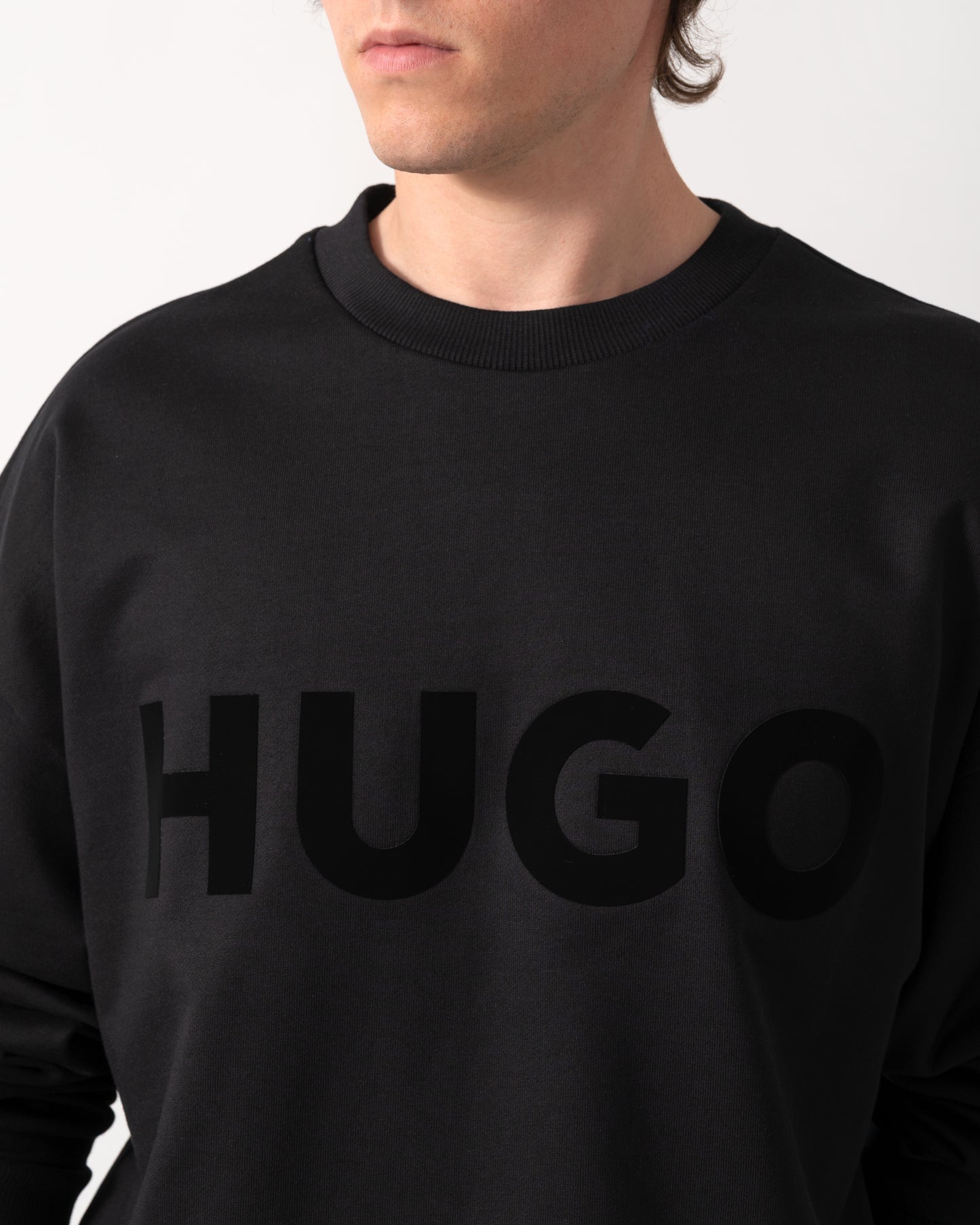 close up shot of a model wearing a HUGO Dinex Mens Oversized-Fit Sweatshirt in Cotton Terry with Tonal Logo in Black 001