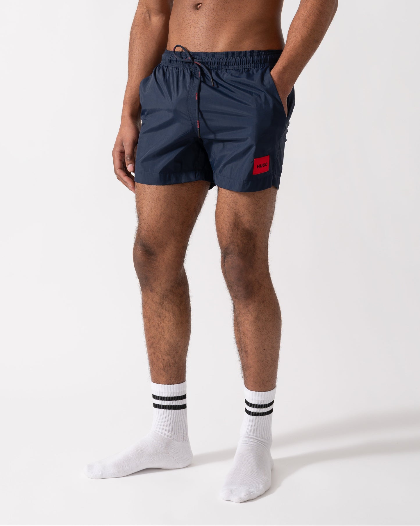 Model wearing a HUGO Dominica Mens Quick-Drying Swim Shorts In Recycled Material With Logo in Dark Blue