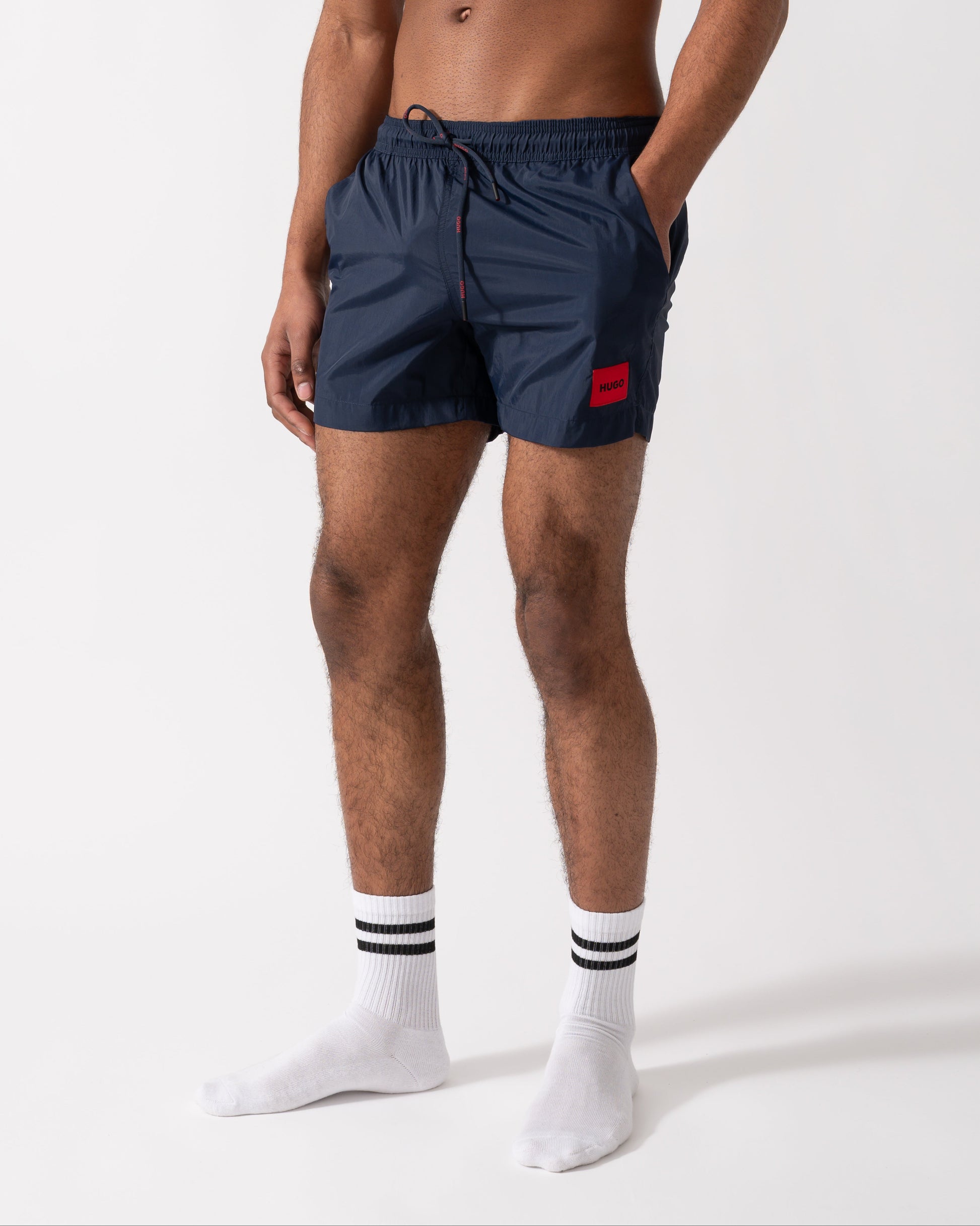 Model wearing a HUGO Dominica Mens Quick-Drying Swim Shorts In Recycled Material With Logo in Dark Blue