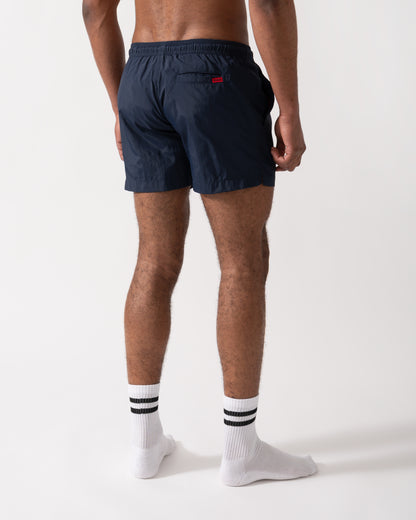 Back shot of a Model wearing a HUGO Dominica Mens Quick-Drying Swim Shorts In Recycled Material With Logo in Dark Blue