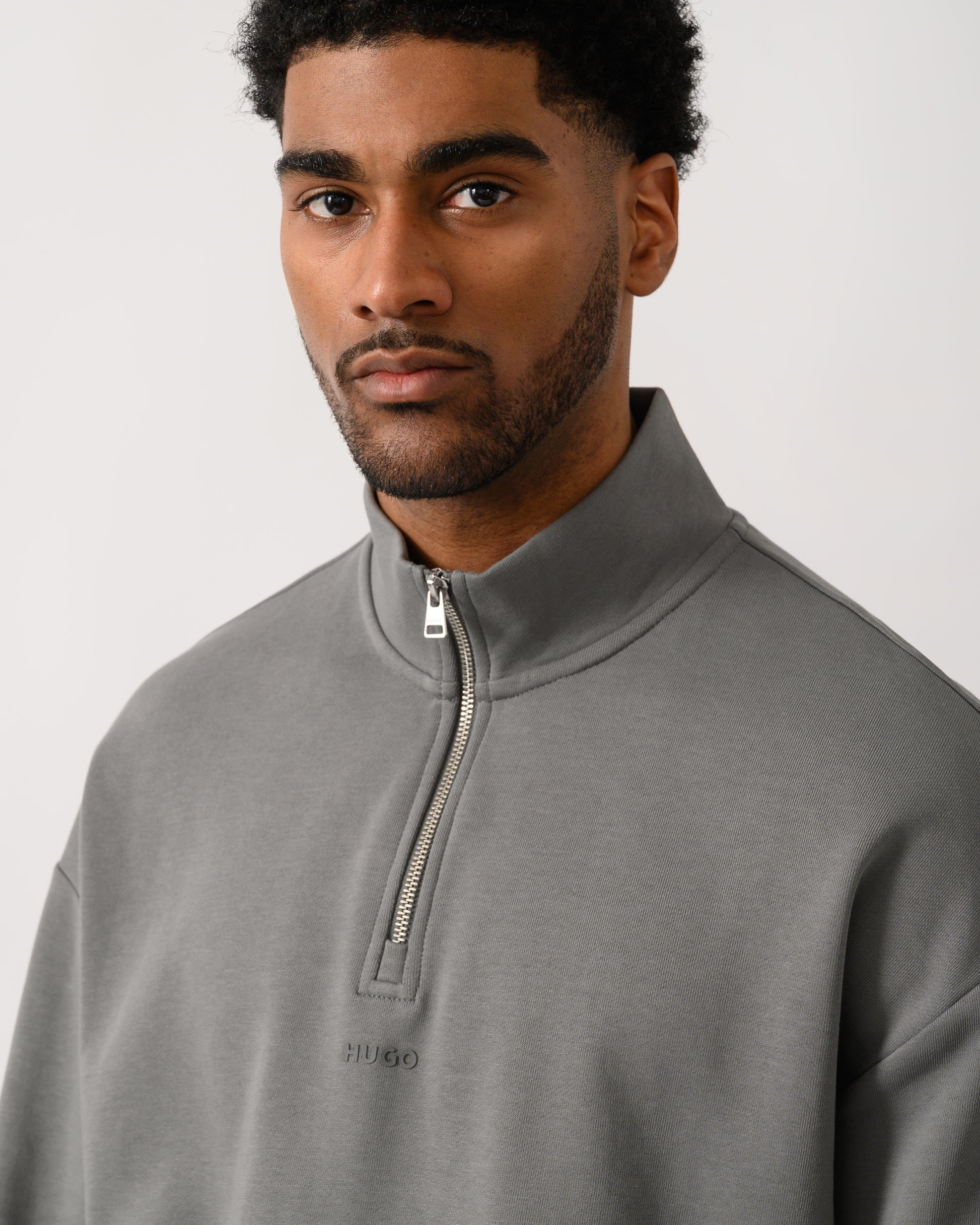 close up shot of a model wearing a HUGO Durty244 Mens 1/4 Zip Sweatshirt in Dark Grey 025