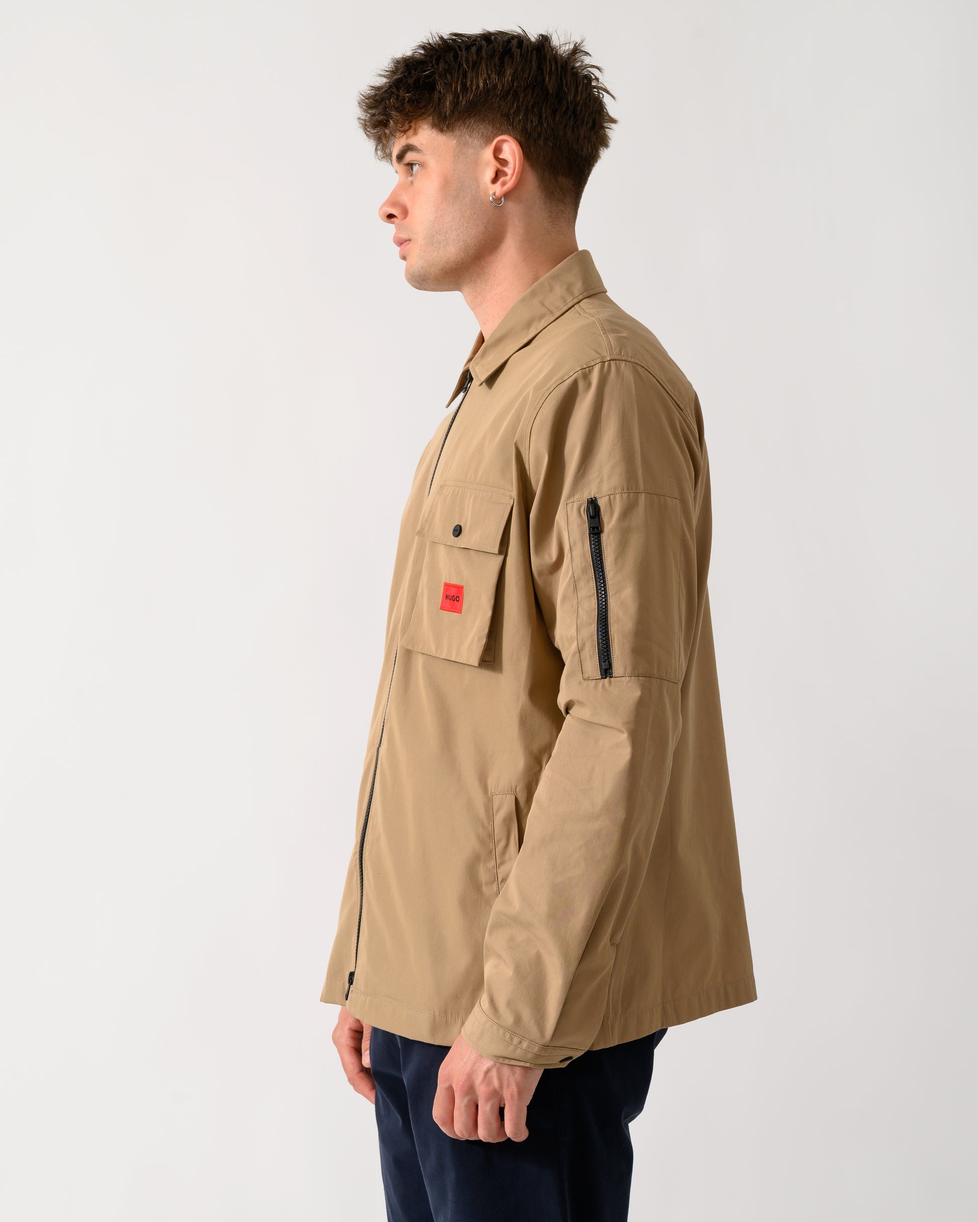 side view of a model wearing a HUGO Emmond Mens Zip Overshirt in Beige Overflow 928
