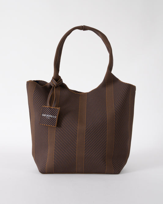 studio shot of Ilse Jacobsen Knitty Womens Knitted Bag in Dark Indigo and Buckthorn Brown