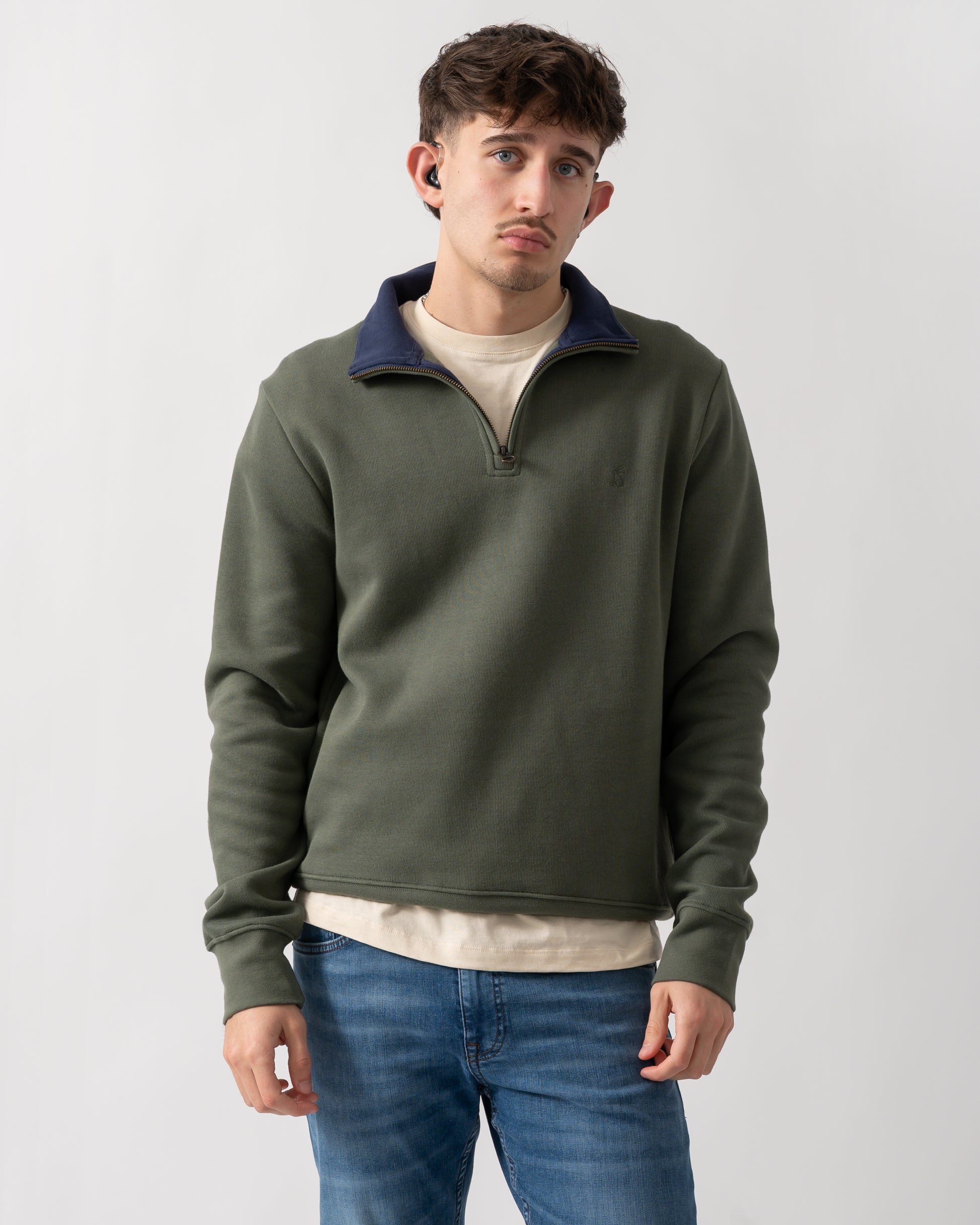 Studio shot of a model wearing a Joules Alistair Mens 1/4 Zip Sweatshirt in Khaki Green