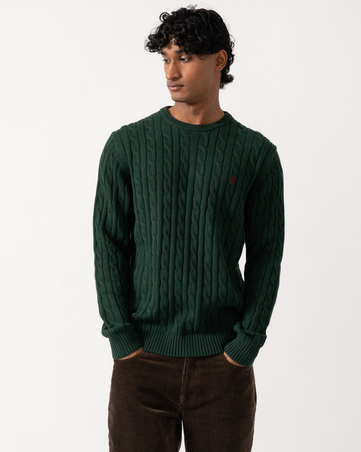 Studio photograph of a model wearing a Joules Mens Cable Knit Crew Neck Jumper in Green