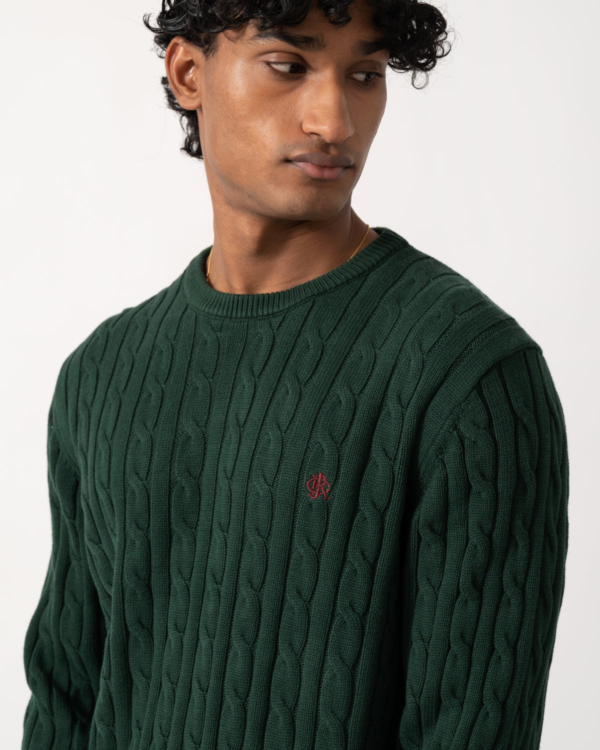 close up Studio photograph of a model wearing a Joules Mens Cable Knit Crew Neck Jumper in Green