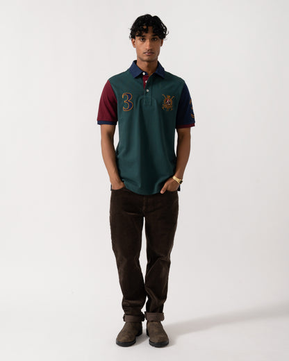 full length Studio photograph of a model wearing a Joules Woody Mens Embellished Polo Shirt in Green/Burgundy