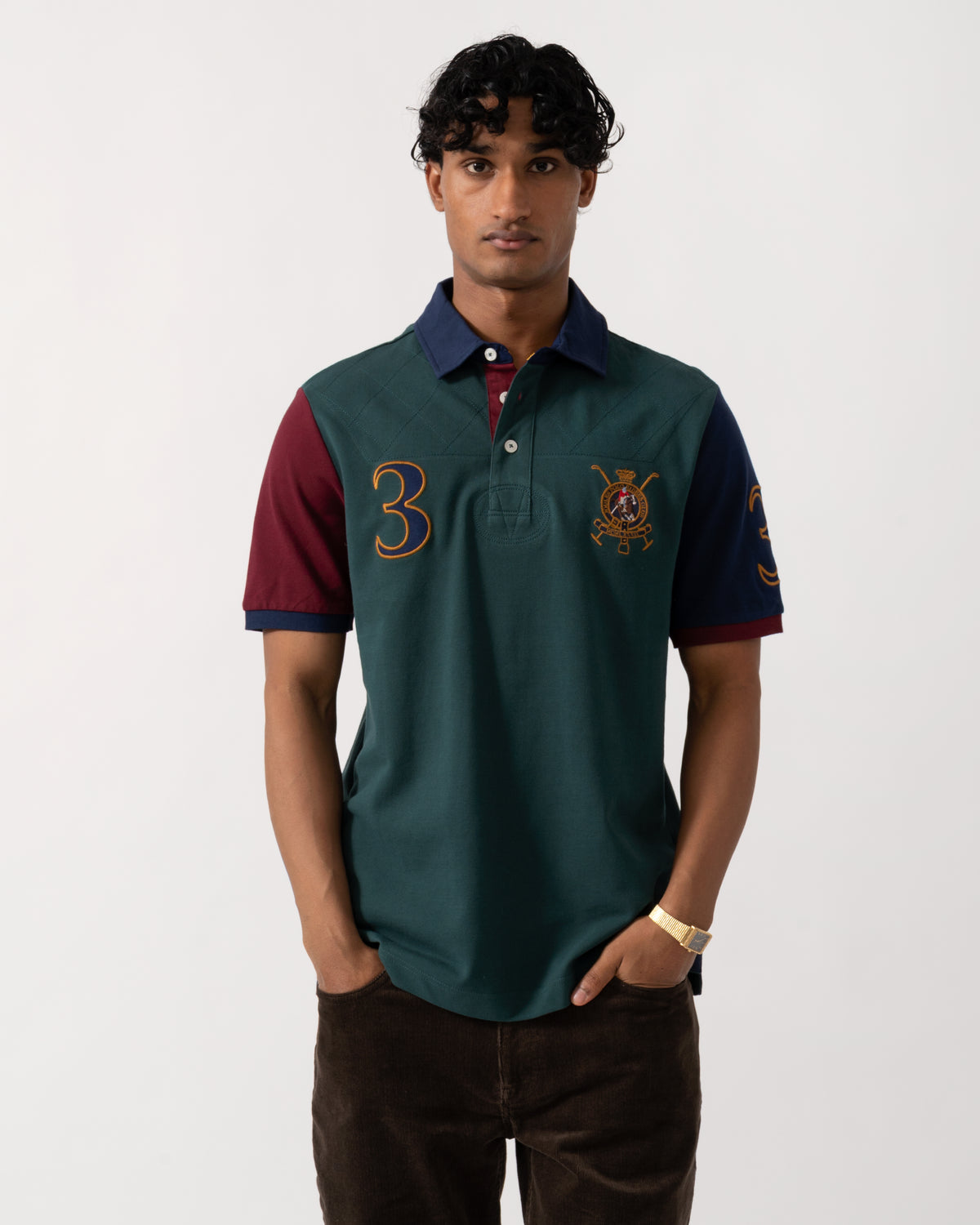 Studio photograph of a model wearing a Joules Woody Mens Embellished Polo Shirt in Green/Burgundy