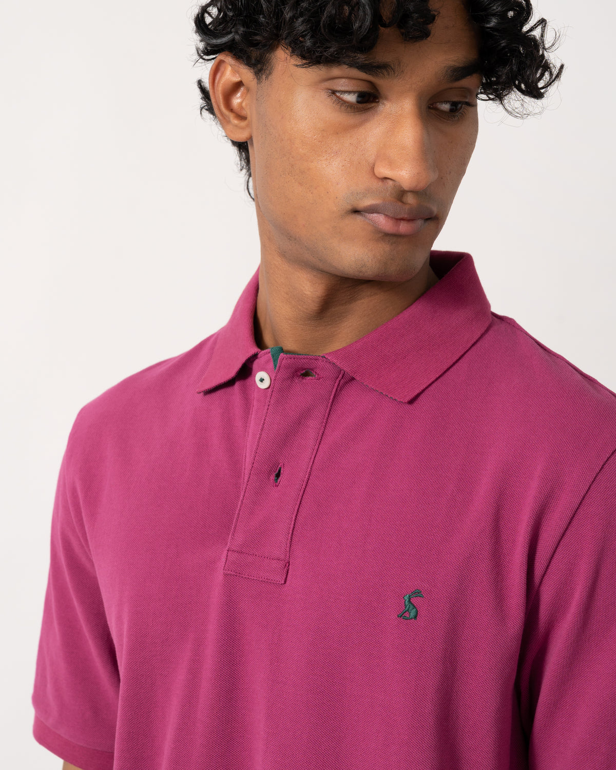 close up studio photograph showing a model wearing a Joules Woody Mens Polo Shirt in Berry Red