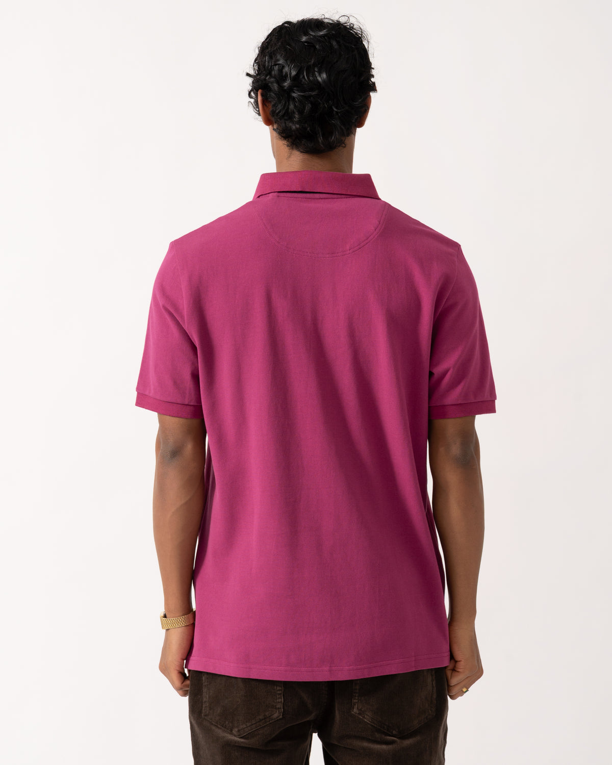 studio photograph showing the back of a model wearing a Joules Woody Mens Polo Shirt in Berry Red
