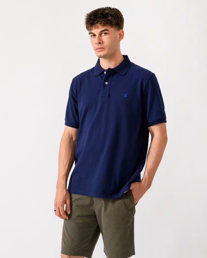 model wearing a Joules Woody Mens Polo Shirt in Dark Navy