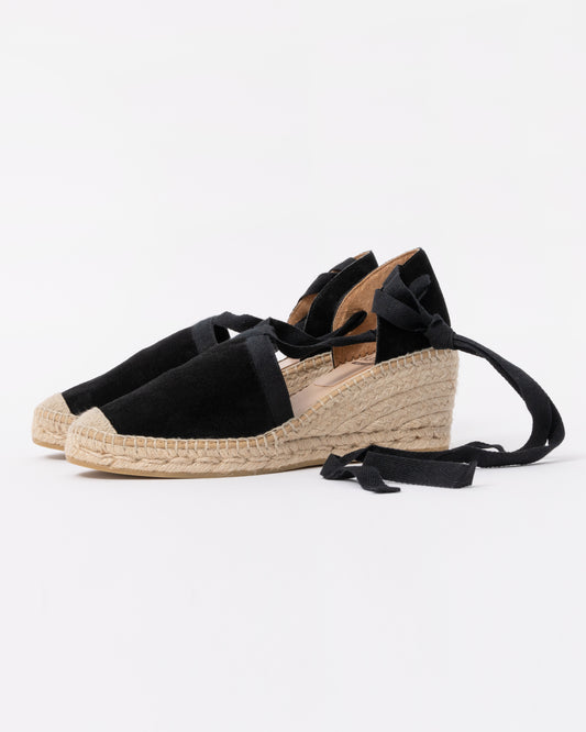 Pair of black wedge sandals with espadrille sole on a white background