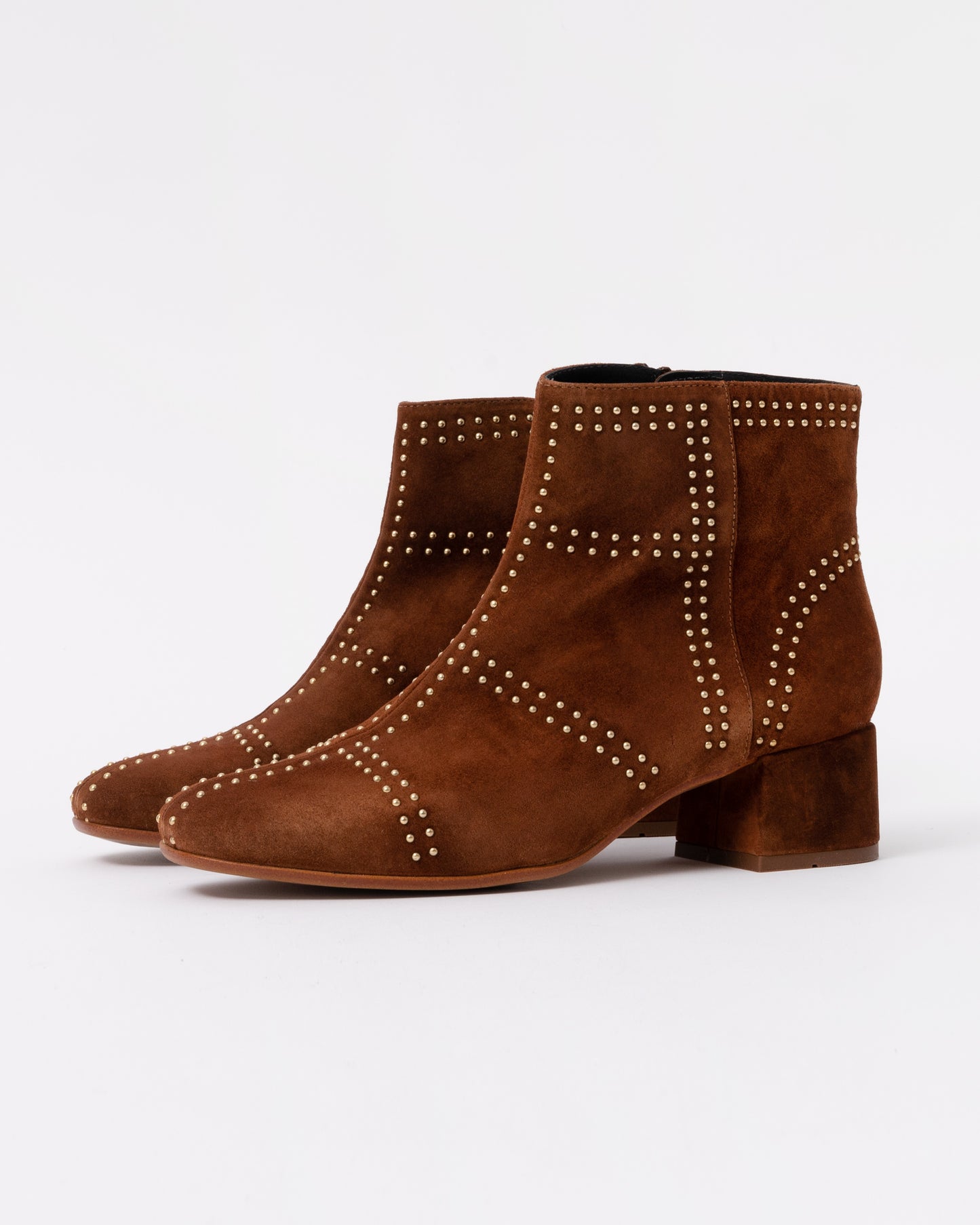 Pair of brown suede ankle boots with studded details on a white background