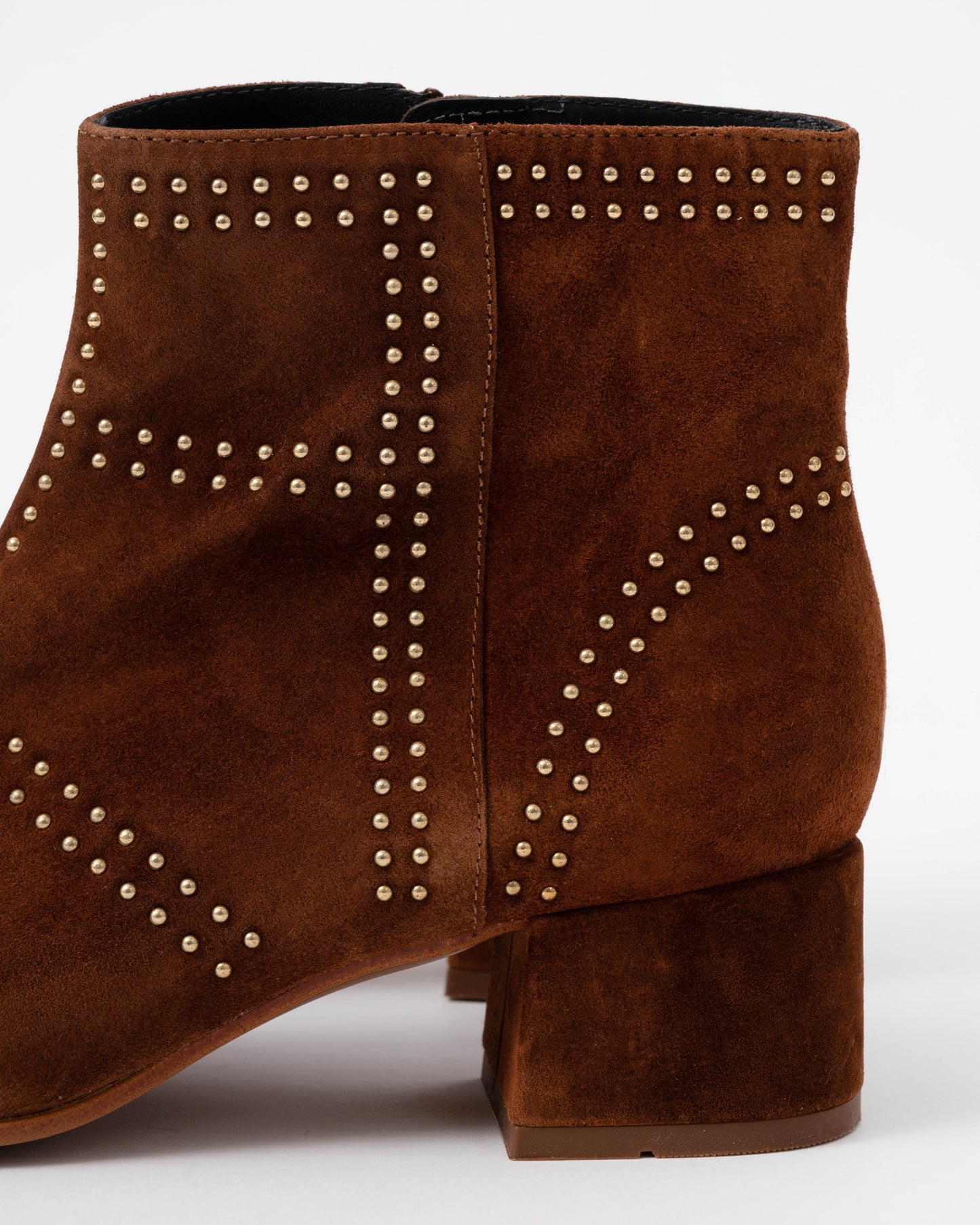 Brown suede ankle boot with studded details on a white background