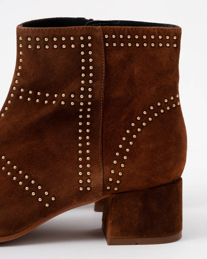 Brown suede ankle boot with studded details on a white background
