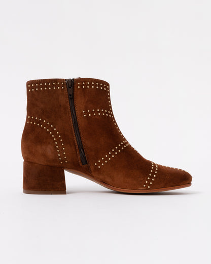 Brown suede ankle boot with studded details on a white background