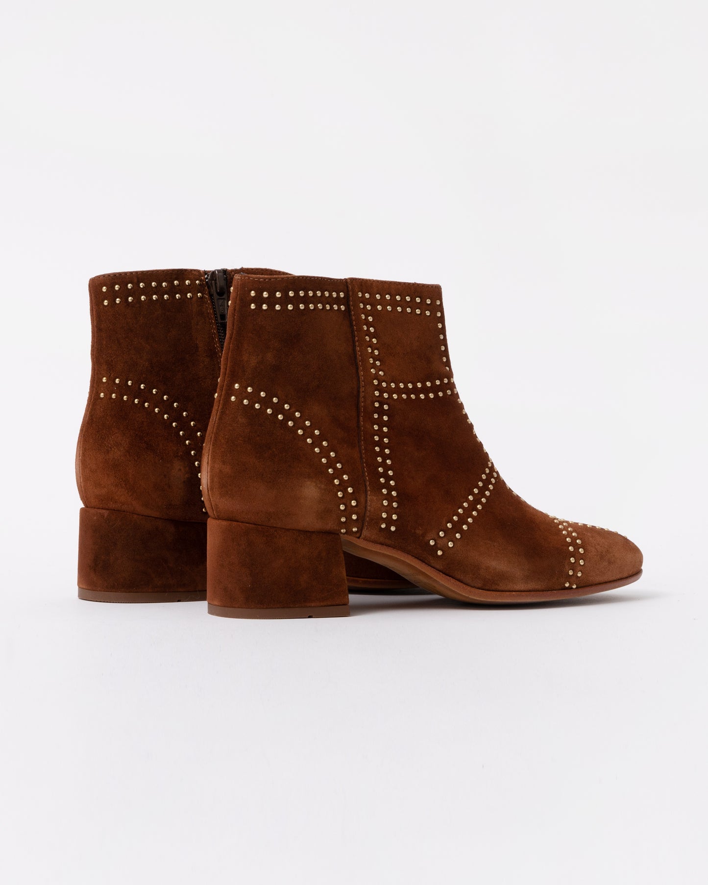 Brown suede ankle boots with studded details on a white background