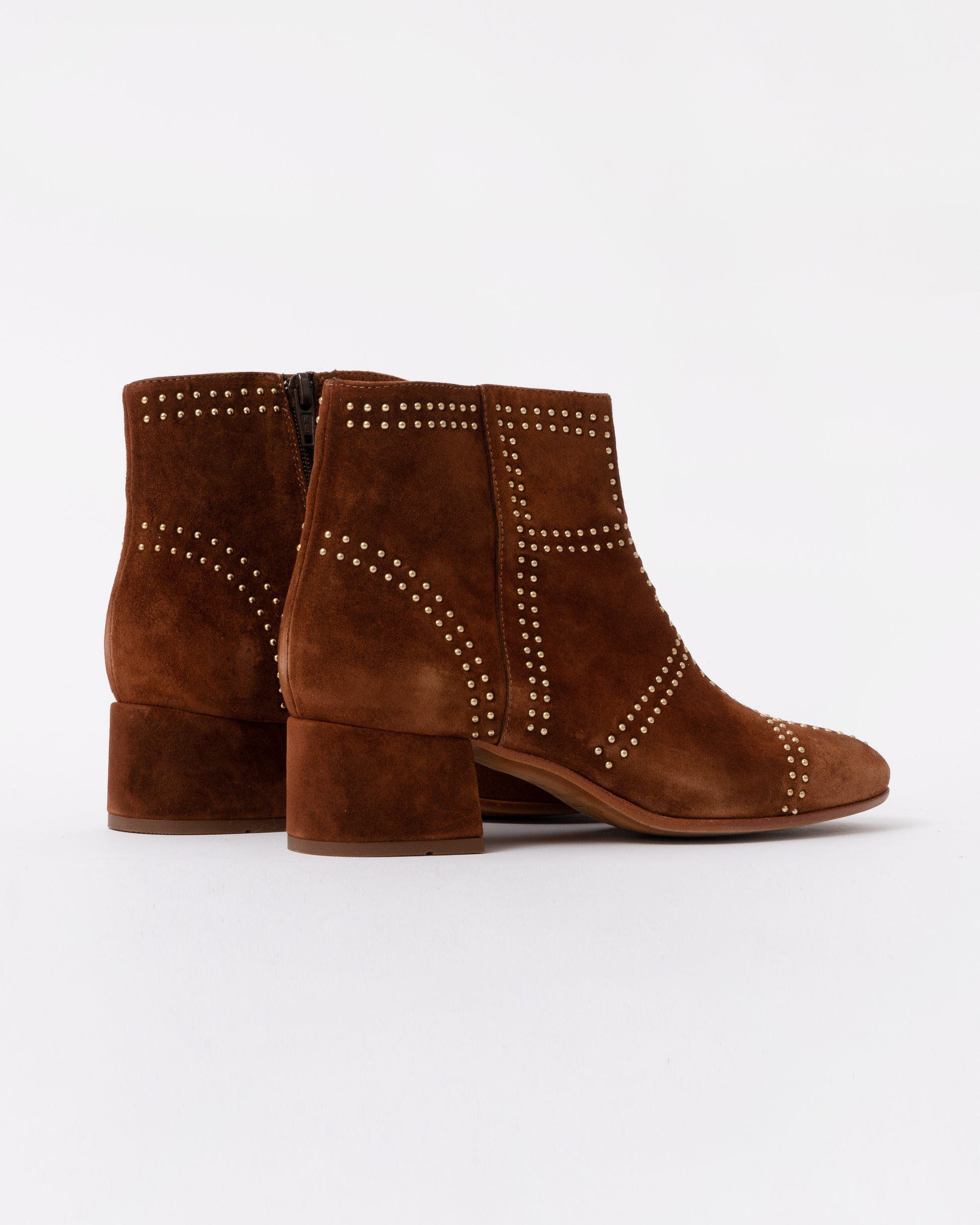 Brown suede ankle boots with studded details on a white background