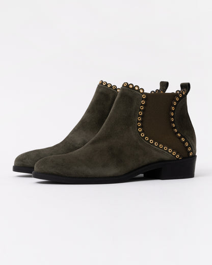Pair of green suede ankle boots with studded details on a white background