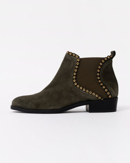 Green suede ankle boot with gold studs on a white background