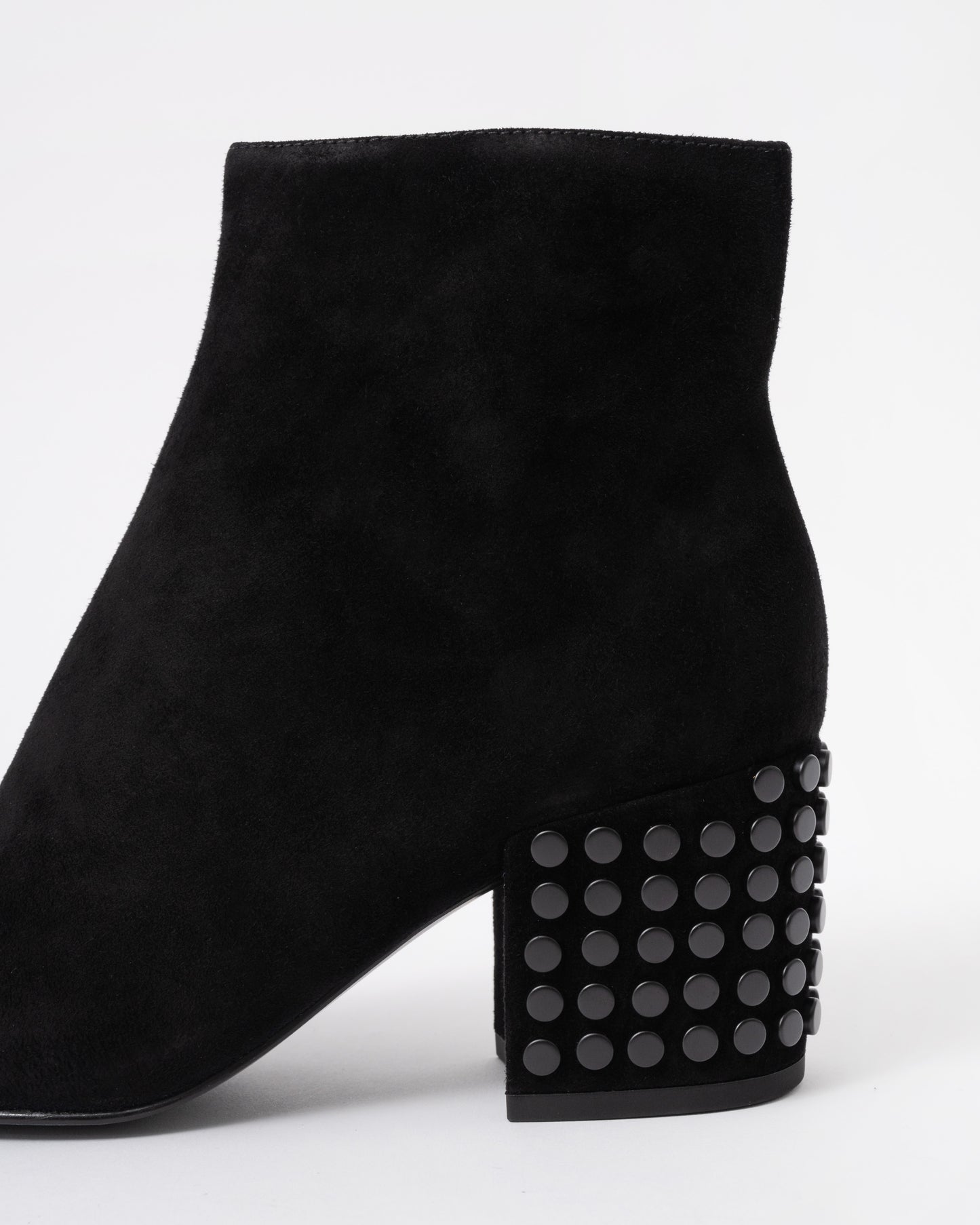 Black suede ankle boot with studded details on a white background