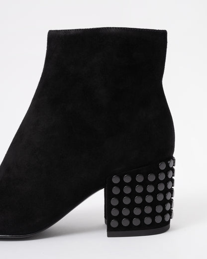 Black suede ankle boot with studded details on a white background
