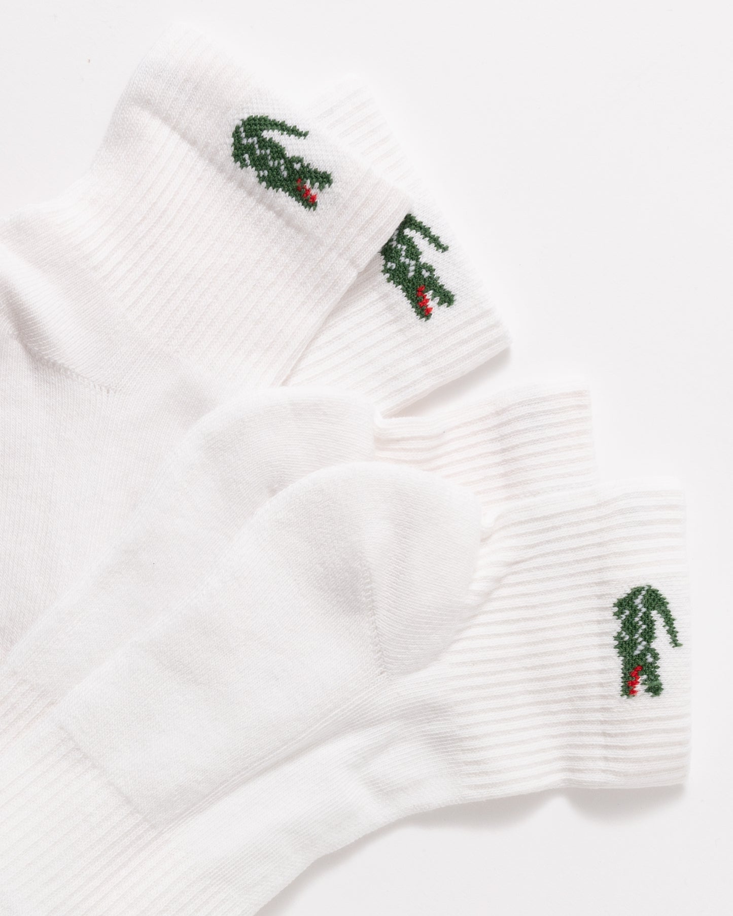 Three white ribbed ankle socks with embroidered green and red alligator motifs on the cuffs, arranged on a clean white background.