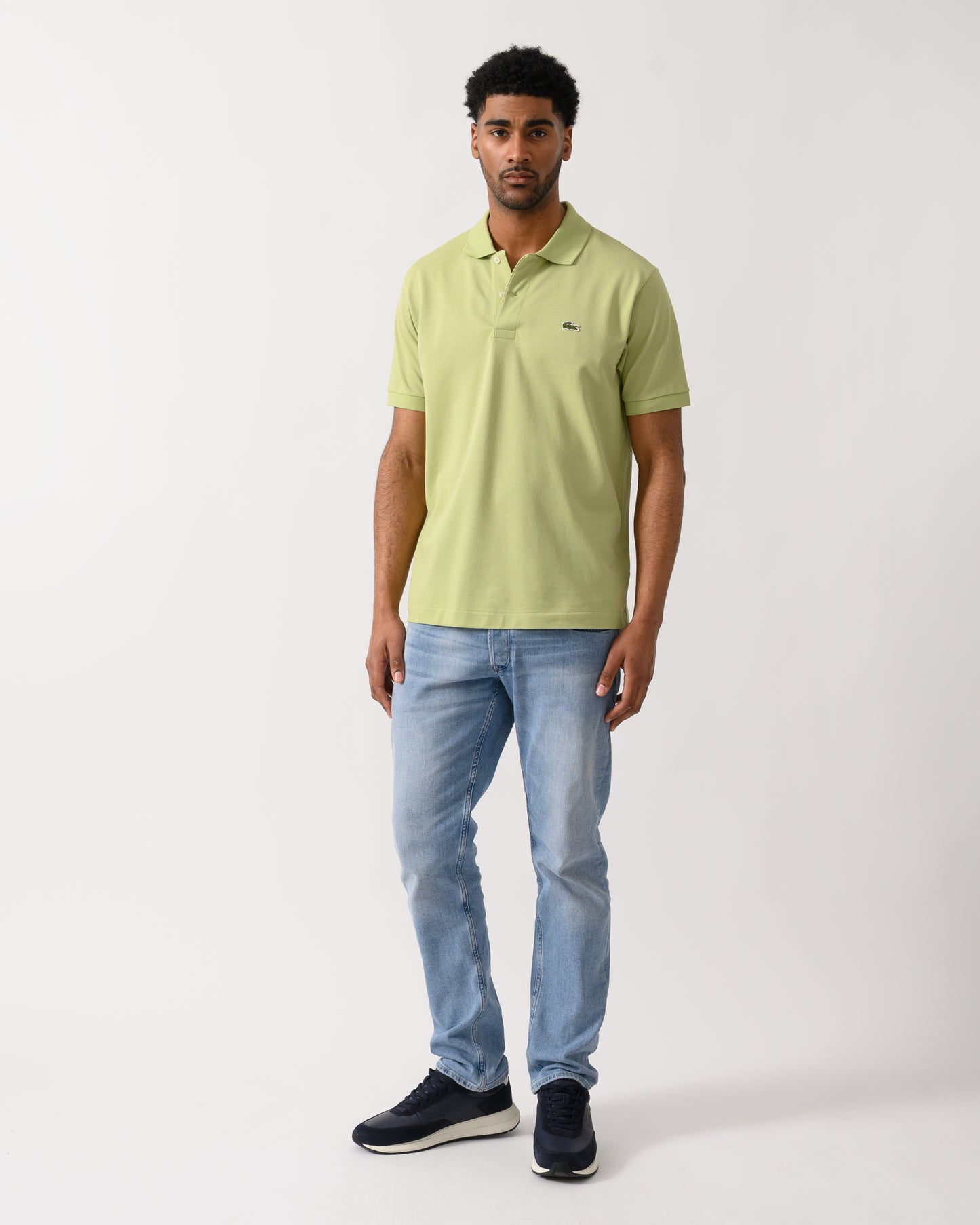 full length shot of a model wearing a Lacoste Classic Fit L.12.12 Mens Short Sleeve Polo Shirt in Birch UYB