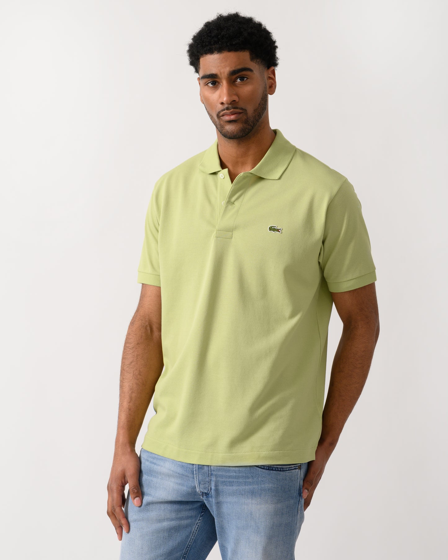 model wearing a Lacoste Classic Fit L.12.12 Mens Short Sleeve Polo Shirt in Birch UYB
