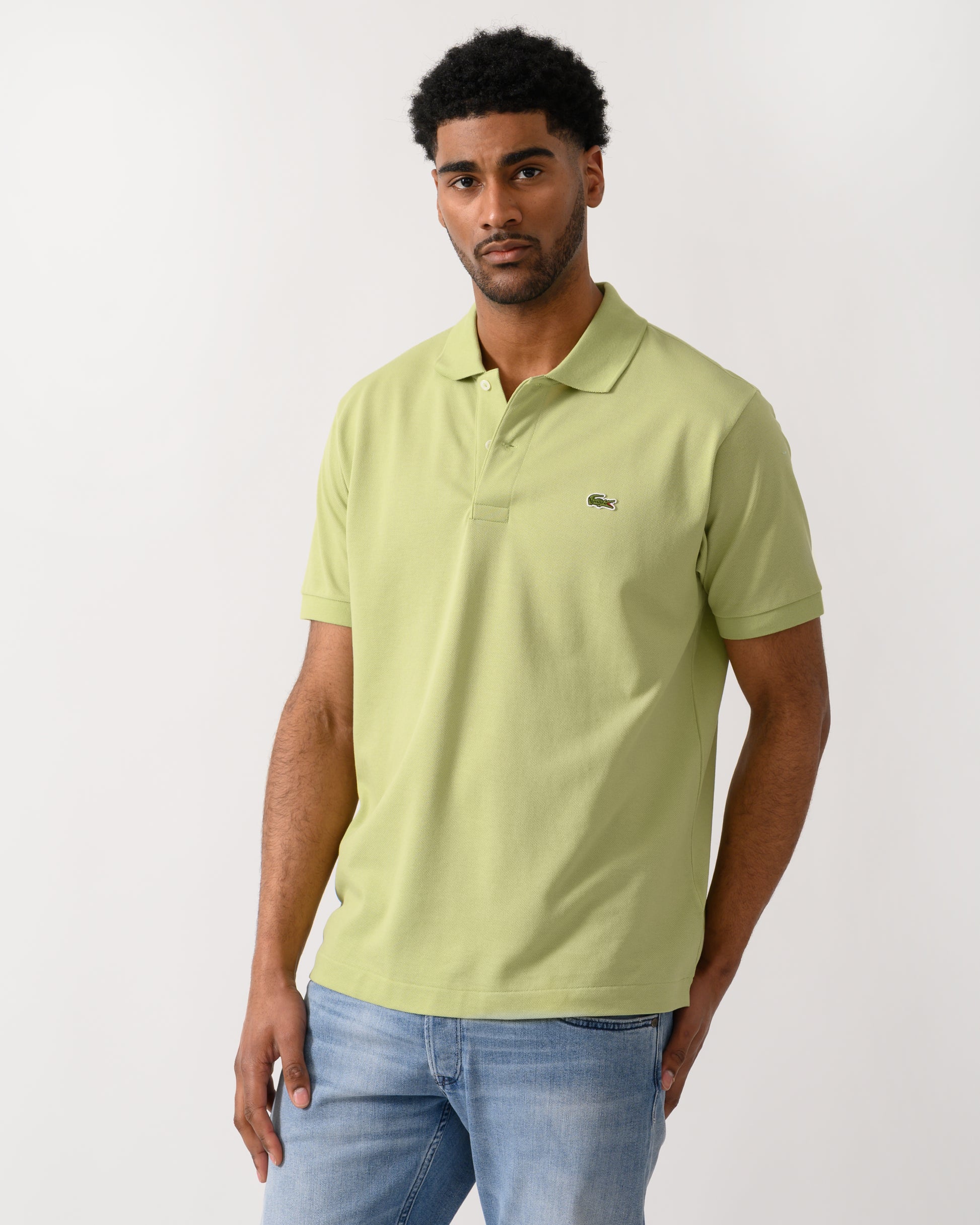 model wearing a Lacoste Classic Fit L.12.12 Mens Short Sleeve Polo Shirt in Birch UYB