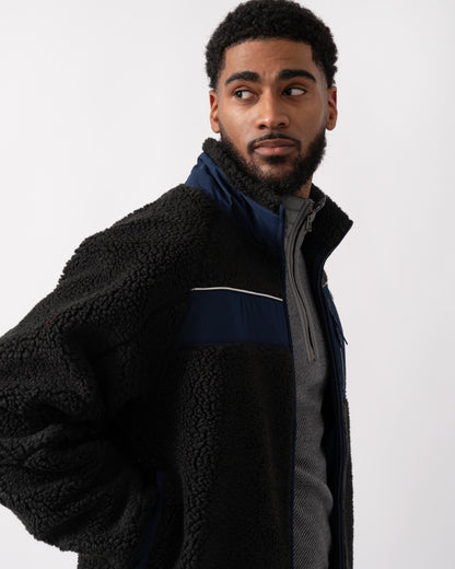 side shot of a model wearing a Lacoste Colorblock Fleece Mens Zipped Jacket in Black and Navy Blue