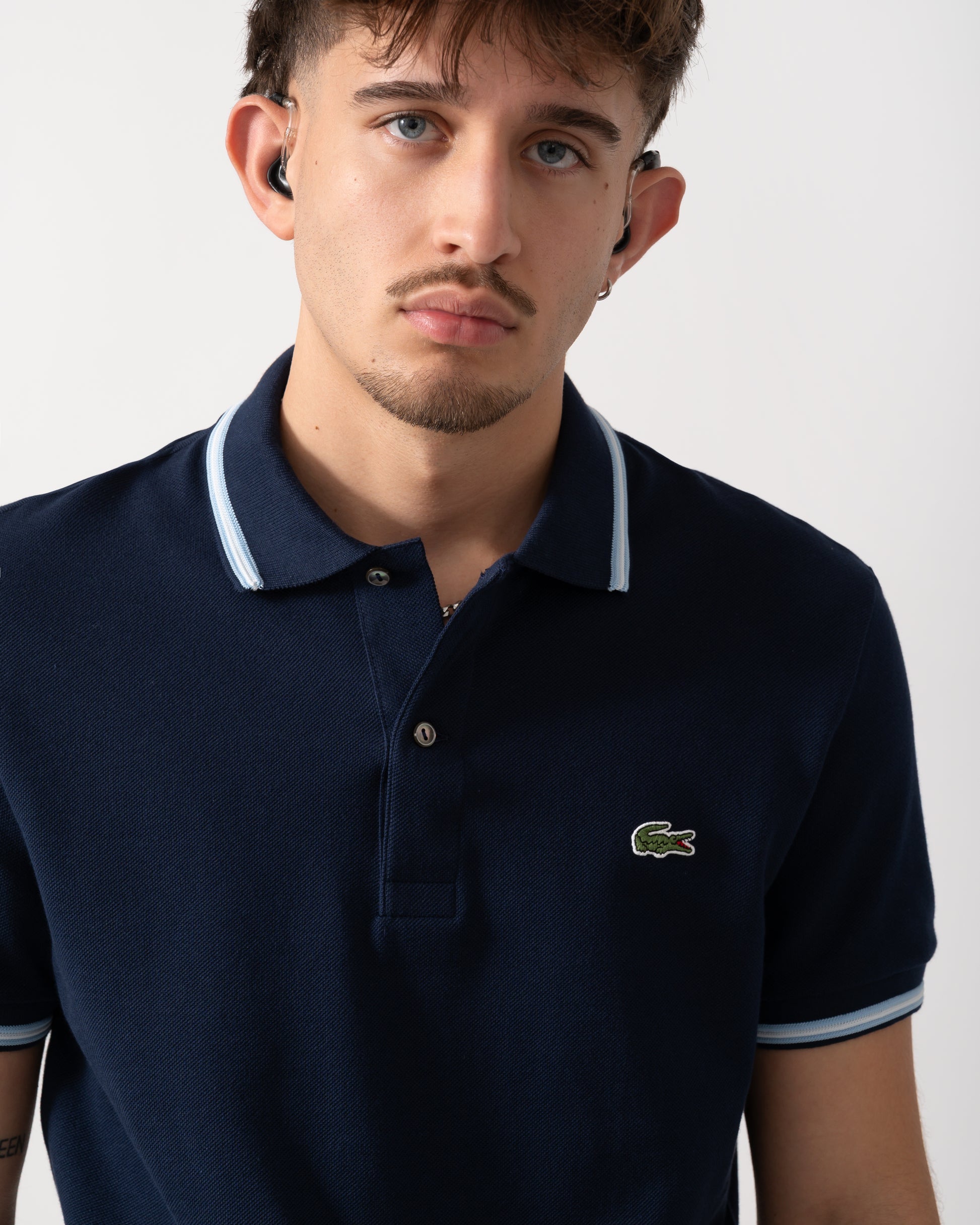 Close up shot of a Model wearing a Lacoste Contrast Collar Pique Mens Regular Fit Polo Shirt in Navy Blue