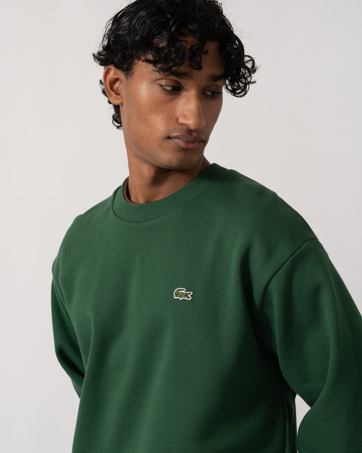 close up Studio photograph of a model wearing a Lacoste Fleece Mens Classic Fit Sweater in Pine Green 132