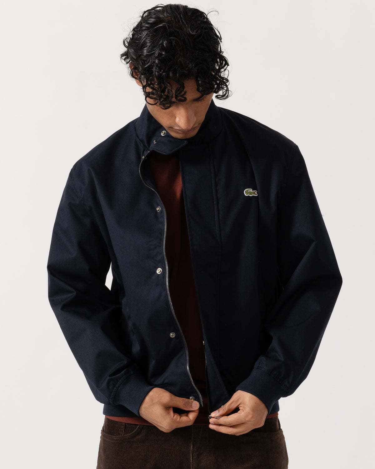 Man zipping up the Lacoste Lightweight Water-Repellent Twill Mens Harrington Jacket - Abysm HDE