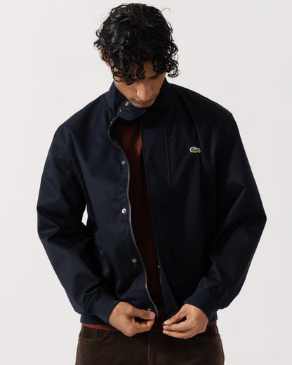 Man zipping up the Lacoste Lightweight Water-Repellent Twill Mens Harrington Jacket - Abysm HDE