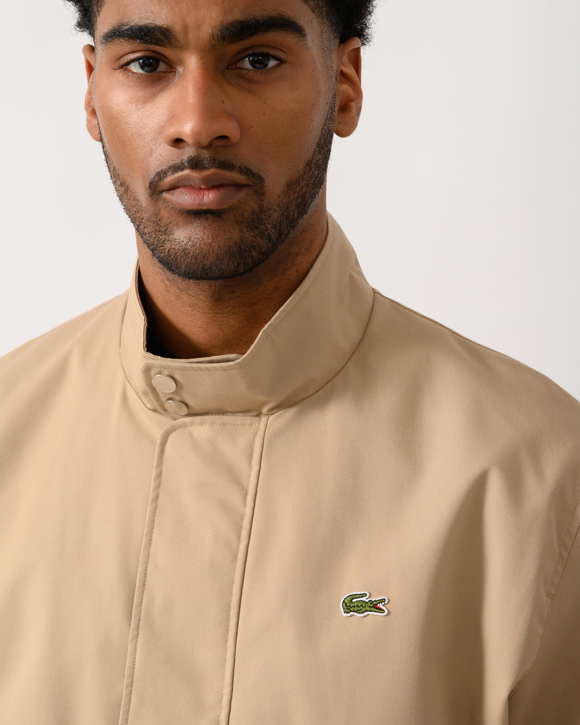 collar detail shot of a Model wearing a Lacoste Lightweight Water-Repellent Twill Mens Harrington Jacket in Viennese 02S