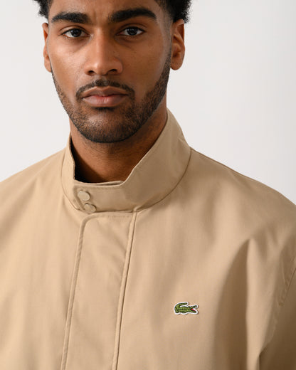 collar detail shot of a Model wearing a Lacoste Lightweight Water-Repellent Twill Mens Harrington Jacket in Viennese 02S