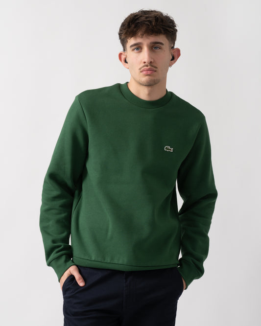 studio shot of a model wearing a Lacoste Mens Crew Neck Fleece Sweatshirt in Green 132